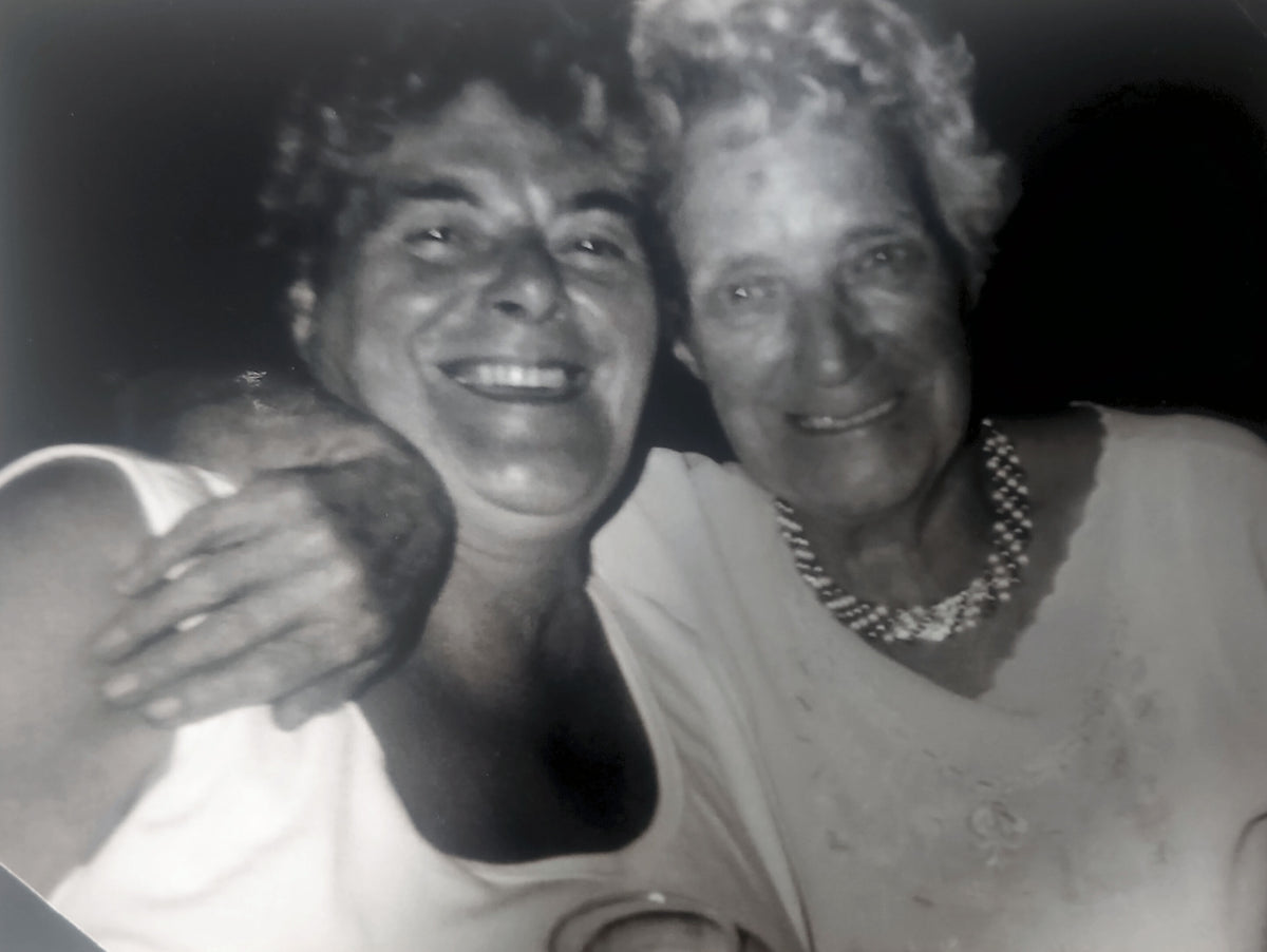 Florence and Amelia smiling together in a close up black and white photograph